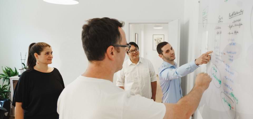 Das Cayas-Software-Team bei der gemeinsamen Konzeption einer App, was die partnerschaftliche Zusammenarbeit unterstreicht.